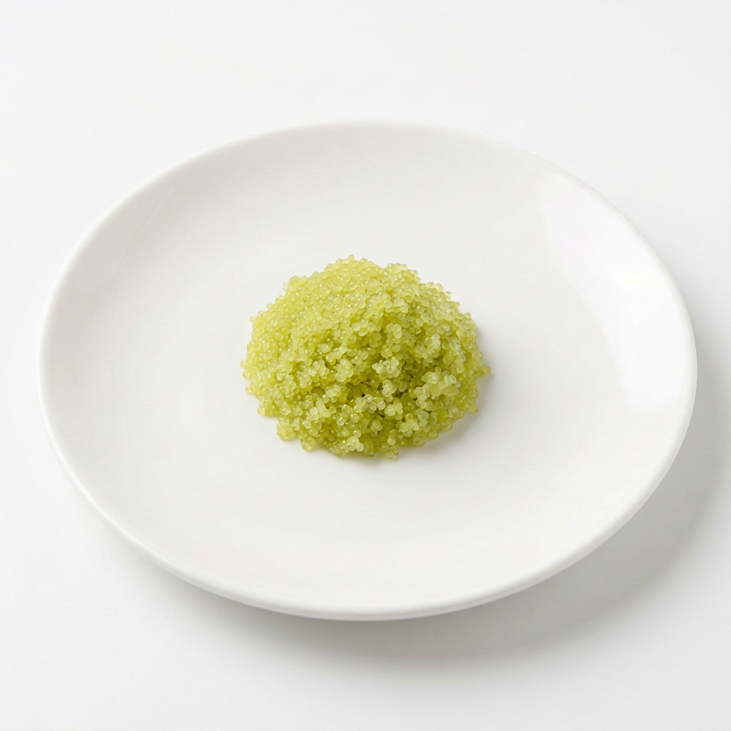 En liten portion grön wasabi-masago fiskrom på vitt fat