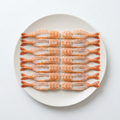 Huvudlösa EBI-räkor för sushitopping med stjärtar på vit tallrik, illustrativ produktbild.