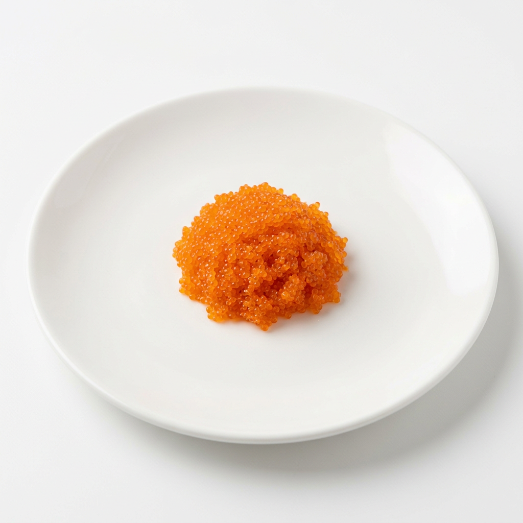 En liten portion orange masago fiskrom på vitt fat